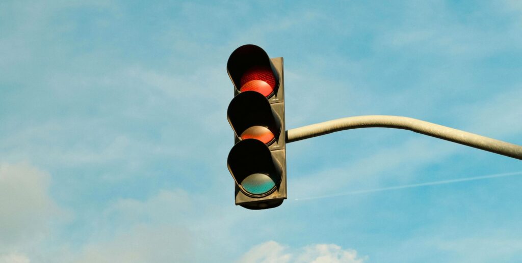 een stoplicht in de lucht met drie kleuren rood oranje en groen