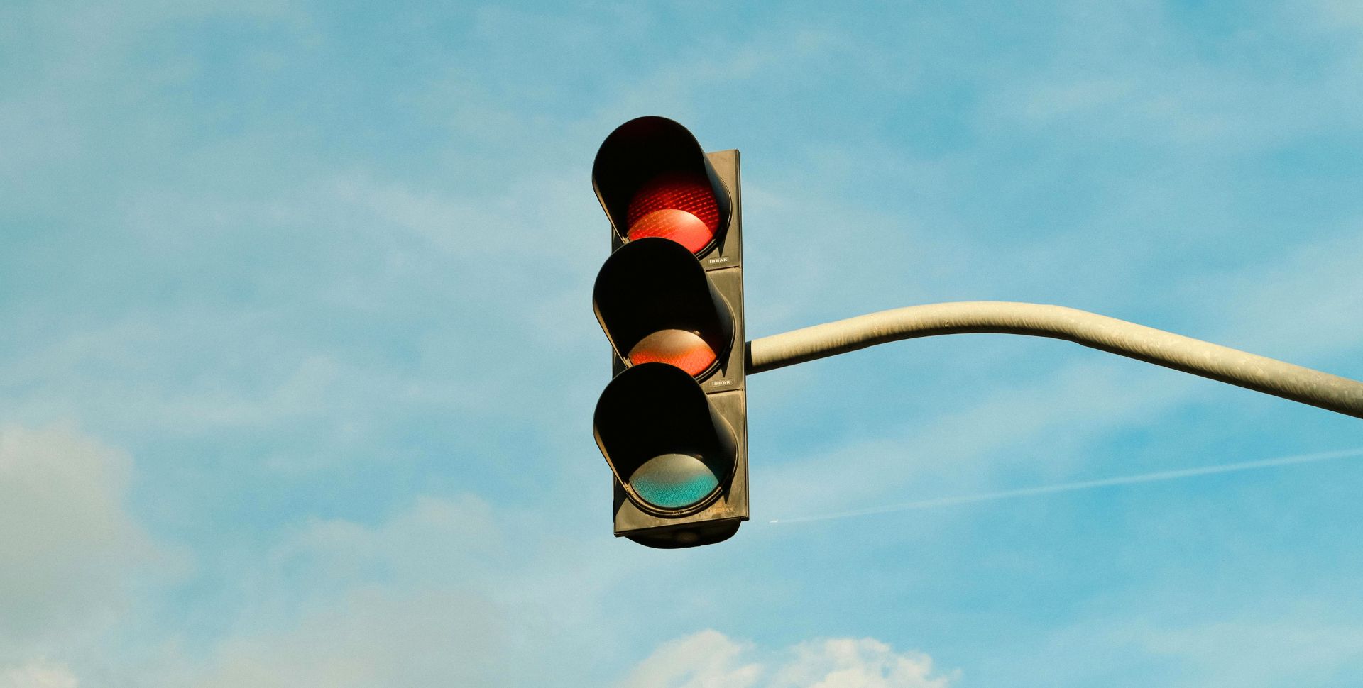 een stoplicht in de lucht met drie kleuren rood oranje en groen