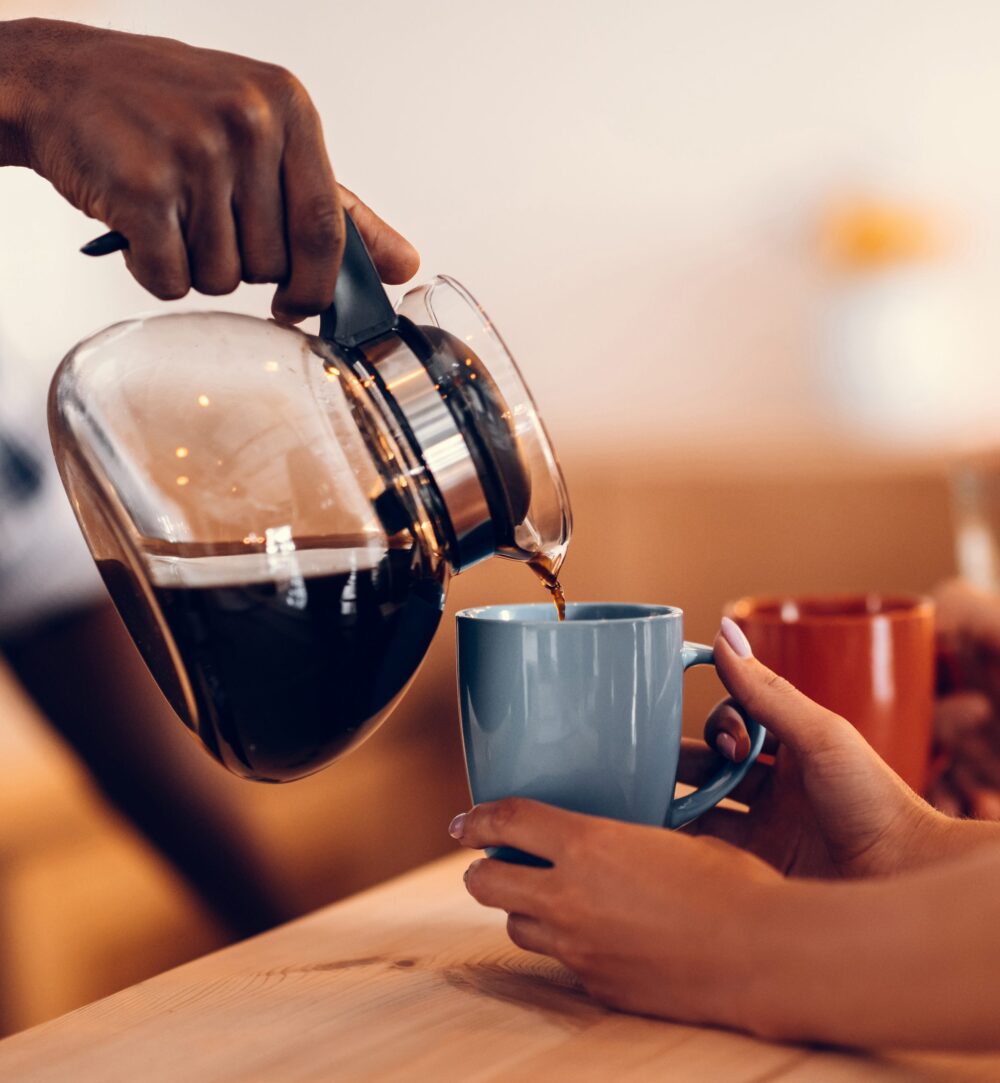 Koffie staat klaar!pouring coffee into cups on bar counter in cafe