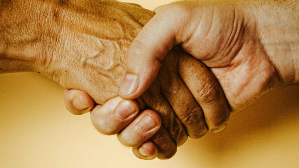 handen schudden symbool van samenwerking de Achterkant en Steunpunt Zelfregie & Herstel