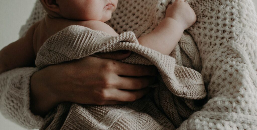 Foto moeder met baby in doeken gewikkeld